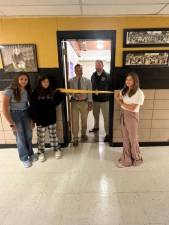 Principal Greg Matlosz and Daniel Novak, the district’s director of education, prepare to cut a ribbon to open the Girls Preparing Closet at Macopin Middle School on Friday, Sept. 29. (Photos provided)