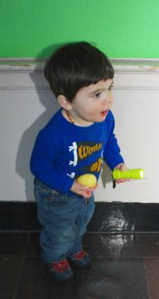 One-year-old Lucas Miranda has used his flashlight well and holds tight to the egg he found on the hunt.