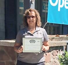 Debbie Johnson is seen outside the West Milford UPS Store holding an award given to the business by the West Milford Economic Development Commission.