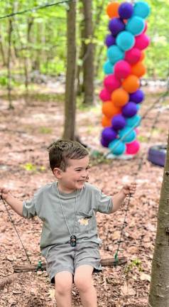 Photos: Learning from nature A child in the Sensory Garden and Play program plays on a swing hung between two trees during family day in June at Camp Wyanokie in West Milford. (Photos provided)