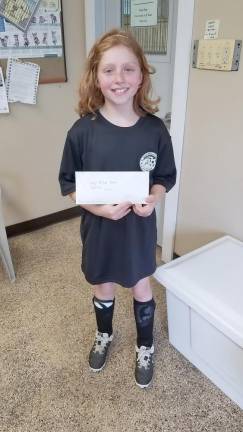 Teagan Slufik donated money from a fundraiser at the Maple Road School TREP$ Marketplace.