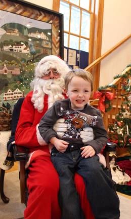 Photos by Ginny Raue A very happy three year old, Nicholas Koster, sits on Santa's lap at West Milford Museum.