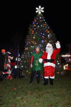 Santa and an elf pose in front of the tree. (Photo by Rich Adamonis)
