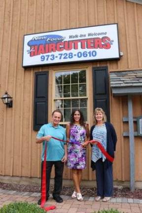 Frank and Diane Curcio, owners of New Focus Haircutters, stand proud at their new location in Bearfort Shopping Village with Mayor Bettina Bieri during the ribbon-cutting. don Webb