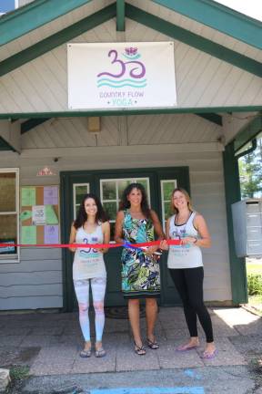 Photos by Don Webb Co-owners of Country Flow Yoga Melissa Gentile, left, and Lara Kowalewski, right, flank West Milford Mayor Bettina Bieri at the grand opening celebration of their studio Sunday.
