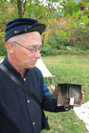 History comes alive at Long Pond Ironworks Sgt. Craig Smith holds a personal lantern, a tin candle stick holder. The door can be opened and closed to avert winds and the candle is kept dry within the holder.