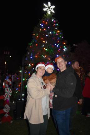 A family poses in front of the tree. (Photo by Rich Adamonis)