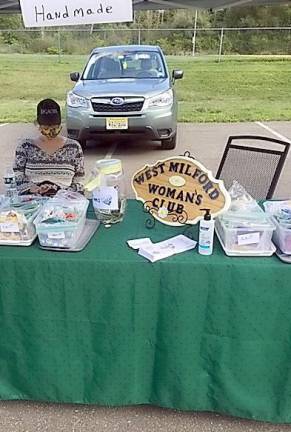 The West Milford Woman’s Club, which has donated more than 2,000 facemasks, scrub hats and headbands to 2,000 to local essential workers, hospitals and seniors in need since March, now have a table at the Farmers Market every Wednesday, where the members are donating these masks to the general public. Photo provided by Pat Spirko.