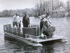 Tom Bruce, center, is seen with two other volunteers on Upper Greenwood Lake in the 1960s taking action against weed growth. The late president of the Upper Greenwood Lake Association served on the Battleship New Jersey that recently celebrated its 80thbirthday. The ship is now a museum in Camden. Photo by Ann Genader