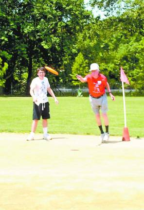 Here we go, West Milford, here we go! Dick Wirth tosses the Frisbee for his team.