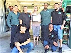 Hilary Esposito holds up the Established Business certificate from the Economic Development Commission. She is joined by the staff of Mountain Lakes Autowash in Hewitt.