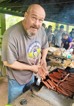 ‘Fishing and family fun’ Councilman Kevin Goodsir, representing the Elks Lodge, cooks hot dogs on the grill.