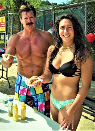 UGL Board Trustee Jim Patton and Samantha Araujo serve hot dogs during the belated July 4 celebration and fireworks last Saturday. Submitted photo