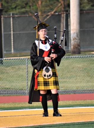 Lone piper Julia Dan performs a bagpipe tribute to her class.