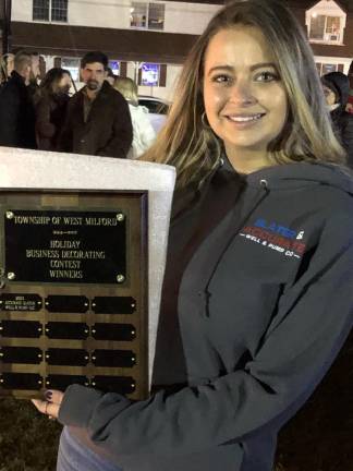 Office manager Karla Cancalosi holds a plaque awarded to Accurate Well &amp; Pump Co./Slater Well Drilling, winner of the holiday-decorating contest. This was the first year that West Milford held a contest for businesses. (Photo by Kathy Shwiff)