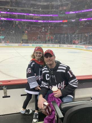Girls on the field, ice, mat Lexie Myrhen, 7, with her dad, Jeff, at a Devils game. (Provided photo)
