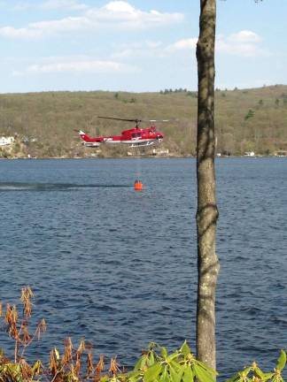 Two forest fires put out Photos courtesy of Laurie Hoppe-Ringer A Forest Fire Service helicopter is seen taking water from Greenwood Lake Monday afternoon to help put out a 5-acre forest fire near Quigley Road.