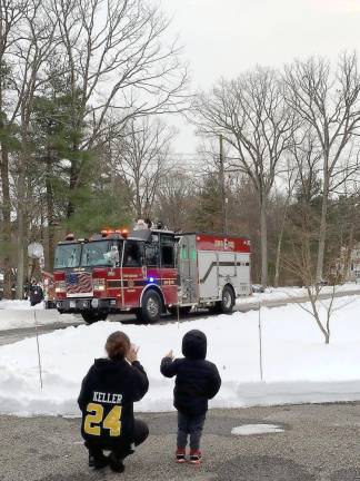 Three-year-old Joey Mandara and his friend/babysitter Krista are excited to see Santa on the WMFD Company 6 firetruck. After Santa passed by, Joey told his mom: “That was spectacular!“ Photo by Patricia Keller.