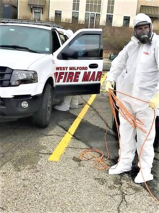 A Serv Pro worker cleans township emergency vehicles at town hall last week.