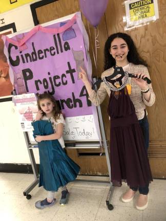 Dress sale helps pay cost of prom bids Sophomore Megan Seidner, right, co-president of the Interact Club, holds a dress to advertise the sale. She is helped by Abigail Scully, 7, daughter of one of the club’s advisers.