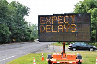 A sign alerts drivers to expect delays on Greenwood Lake Turnpike due to paving work.