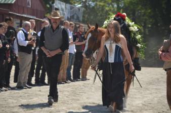 Katie Benson leads the empty saddle procession at Wild West City on Aug. 4, 2019. Katie was Michael Stabile's niece (daughter of Ron and Mary). To Katie's right is Ron Benson, who is married to Mary Benson, sister of Michael.