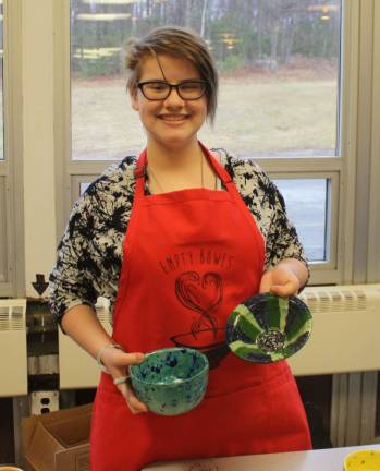 Emily Schwab, 16, holds up two of the bowls that were available at Empty Bowls fund raiser. The bowls were all handmade by West Milford High School art students. Such a tough choice!