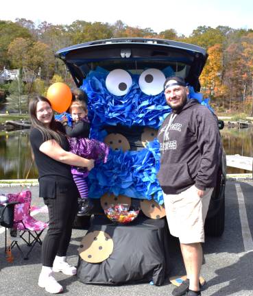 UGL Clubhouse hosts trunk or treat Ali, Jules and Dan Archettis are shown in front of a cookie-monster themed trunk.