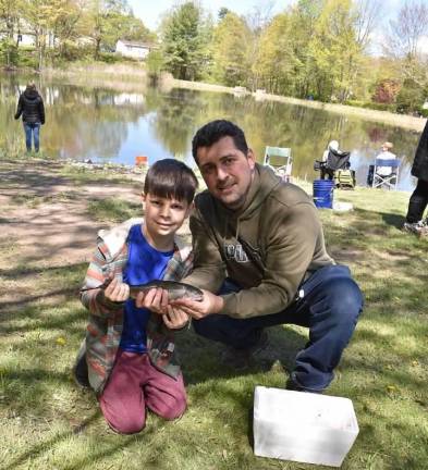Daniel Mosolygo, 10, and his father, Denes, show the trout they caught at the Kids Trout Fishing Derby.