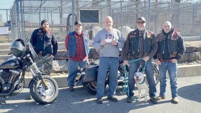 Members of the Warlocks motorcycle club from Sussex County made a $3,500 donation to the West Milford Animal Shelter Society on Saturday, Feb. 18. Club members pose with shelter president Paul Laycox, center, and a newly arrived pup named Blue. They toured the facility, met with volunteers and visited several of its animal guests. ‘This motorcycle club has been nothing short of amazing in supporting us,’ Laycox said. ‘These guys are animal lovers interested in supporting our mission.’ (Photo provided)