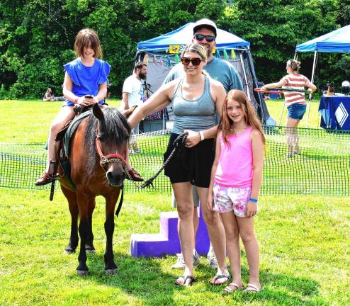 Crowd enjoys food, music, fun MF2 The Gratale family of West Milford at the pony ride. At right, a woman tries a hula hoop.