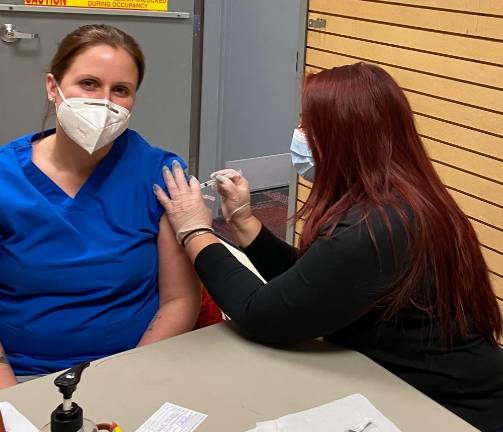 Wantage resident Ashlie Qualagari, an LPN at Wellness Center Pediatrics, receives her COVID-19 vaccine from RoNetco’s Nicole Gong, PharmD.