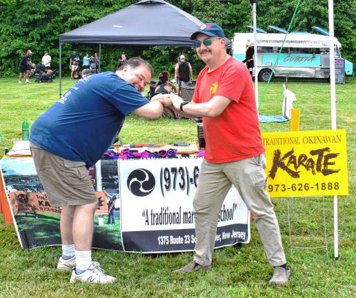 Crowd enjoys food, music, fun MF3 Isshin-ryū karate instructors Rob Banks, left, and Christopher Miller demonstrate the waterfall joint lock.