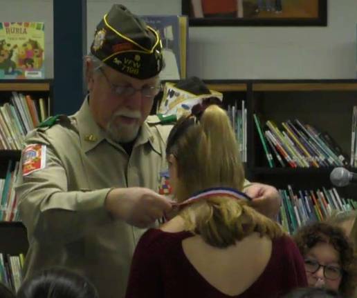 Photo by Patricia KellerJillian Bennett receives a medal from VFW Commander Bill Johnson for her third place win in the annual &quot;Voices of Democracy&quot; essay contest.
