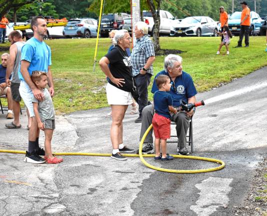 Community gathers for National Night Out A boy takes a turn pointing the fire hose during the National Night Out event Tuesday, Aug. 5 at West Milford High School. (Photos by Fred Ashplant)