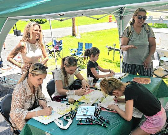 Community Day features street fair Children and adults at the crafts table.