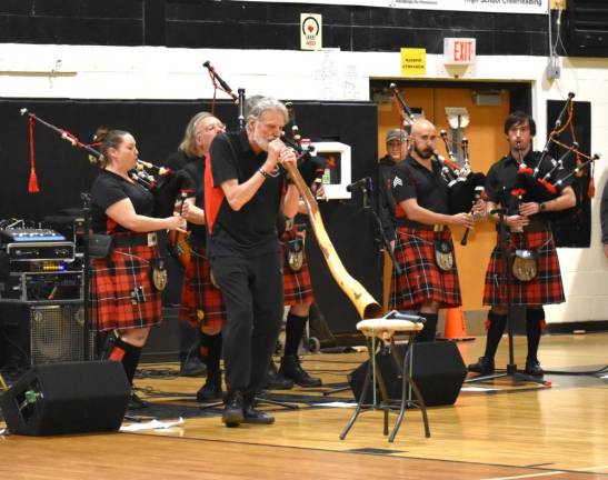 A member of the Bergen County Firefighters Pipe Band plays a didgeridoo.