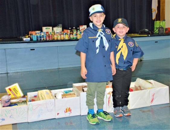 Scouts Douglas and Calvin Lewis join the pack in preparing food donations Nov. 22.