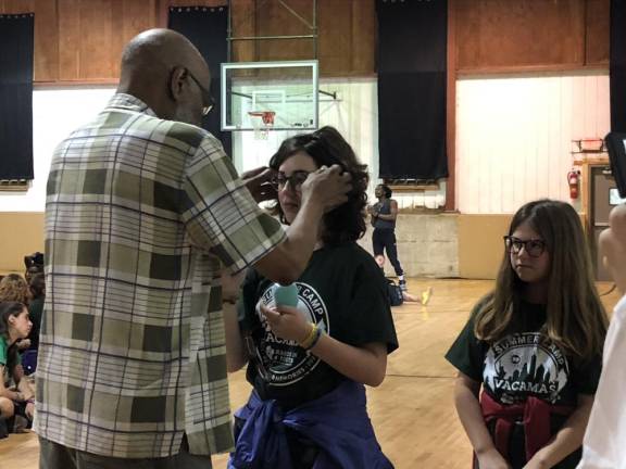 Campers given free glasses Optician Floyd Patterson helps fit new glasses on a camper.