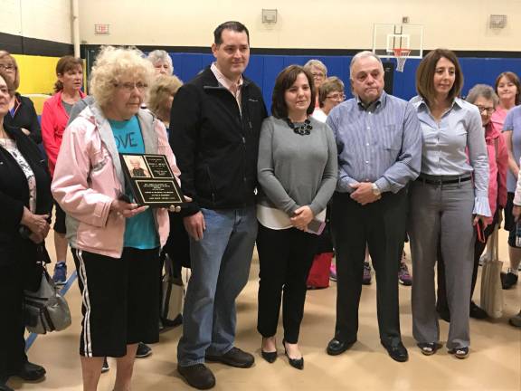 Barbara Cox, left, one of the many seniors who were inspired by the late aerobics instructor Susan F. Swartz, holds a plaque that is now displayed in the township's Recreation Center. Second from left are: Swartz's son-in-law, David Carver; daughter Stacy Carver; Swartz's husband, Dan; and daughter Dana Swartz.