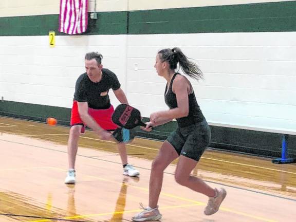 Rich Lenihan prepares to return the pickleball as Nicole Rydzewski watches. (Photo by Kathy Shwiff)