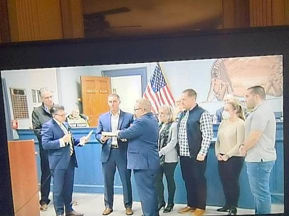 Newly elected West Milford Councilman Matthew Conlon is sworn in surrounded by family members at the Jan. 4 reorganization meeting. State Assemblyman Christian Barranco, left, and state Sen. Anthony M. Bucco, second from left, administer the oath. (Photos by Ann Genader)