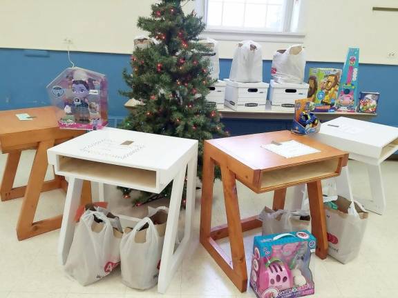 A local craftsman, Bill Schmidt, has been building beautiful, functional desks for children that measure 27 inches wide by 20 inches deep by 29.5 inches high. His goal is to give a child their own place at home to do homework. No more doing it on the kitchen table or living room floor. He is making these to give away free to families in need. If your child needs a desk, please contact the Community Pantry at 973 768-9468 and your request will be forwarded to him. The picture was taken at the West Milford Presbyterian Church during their free Christmas dinner give away. Photo and information provided by Bonnie Seufert.