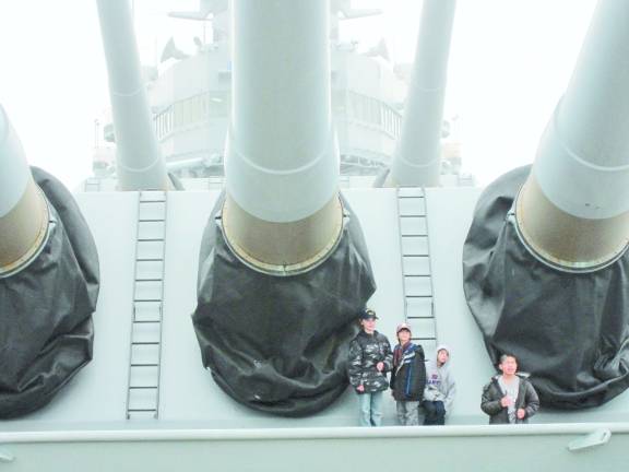 Battleship New Jersey wows the scouts Cub Scouts from Pack 51 pose for a picture by the massive front gun turrets of the Battleship New Jersey.