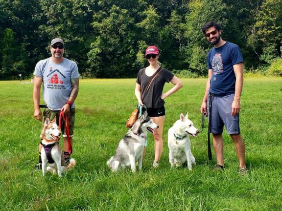 A Husky named Wylie, left, was adopted at the walk by a family with two other Huskies.