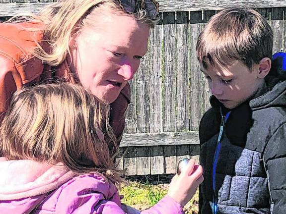 Madison Valerie, 4, shows off a gold egg that she found. Only six were hidden in the Easter egg hunt. At right is her brother Robert, 5.