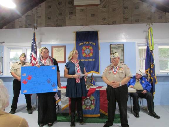 Teachers Kelly Frasca, left, and Jill Cullen present Bill Johnson, commander of West Milford Veterans of Foreign Wars Post 7198, with a check for $2,763.