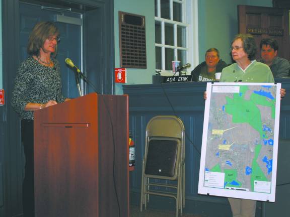 Linda Gloshinski, left, talks to the township council earlier this month, as Marilyn Lichtenberg holds the map depicting the parcels of land being considered for purchase by the township.