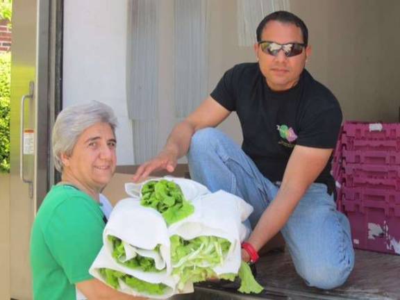 Sister Theresa loading lettuce onto the Table to Table delivery truck
