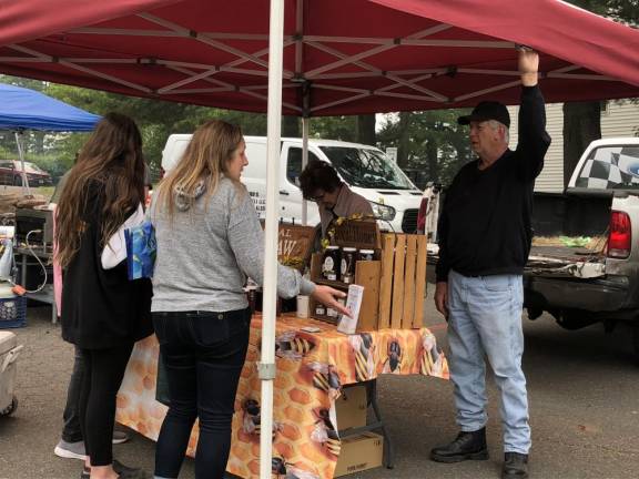 Shoppers look at the products sold by John and Donna Coco of Top of the Mountain Honey Bee Farm in Wantage. They have been part of the West Milford Farmer’s Market for 15 years.